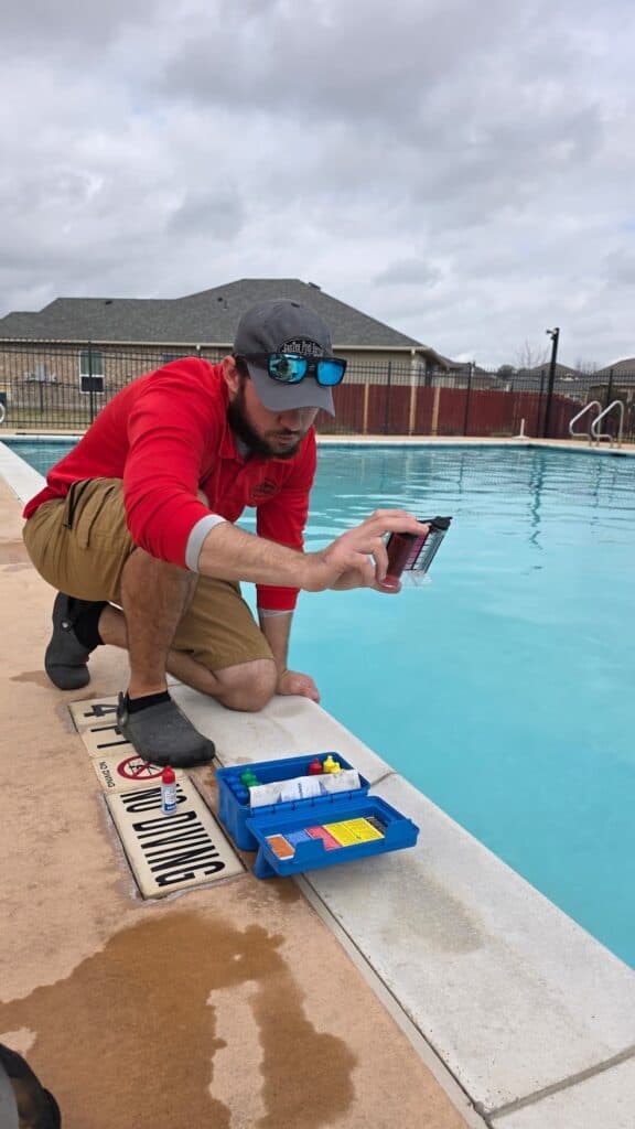 Pool technician testing water chemistry during pool service in Temple Texas