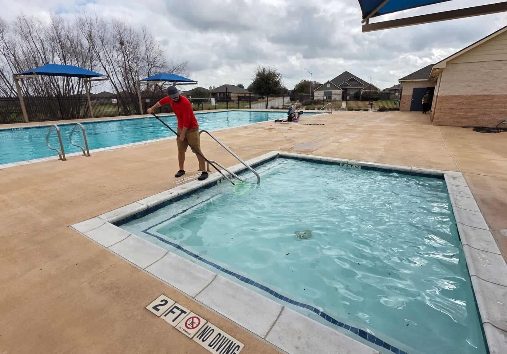 Pool technician cleaning spa during weekly pool service in Belton Texas